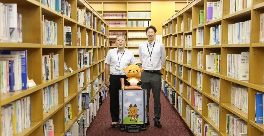 左から、村田 直史様(奈良市)、書架案内ロボット「しかまろくん」、内田 雄規(京セラコミュニケーションシステム株式会社)